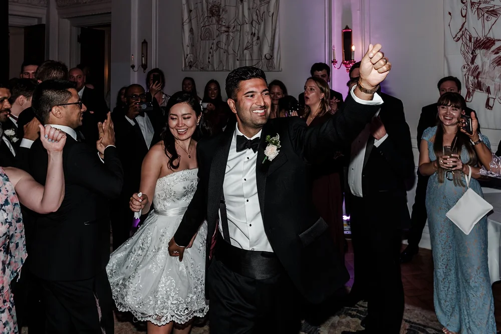 Newlyweds with their hands in the air walking back down the aisle at The Ned