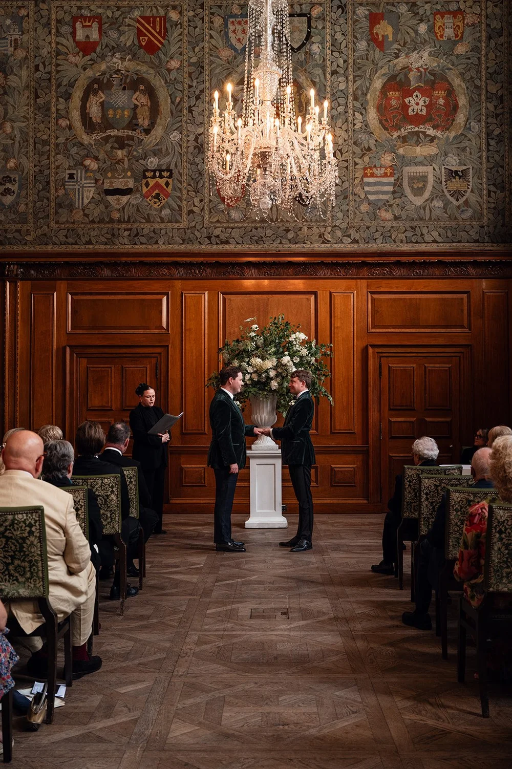 The Tapestry Room at The Ned set for a wedding ceremony, chandelier above the aisle