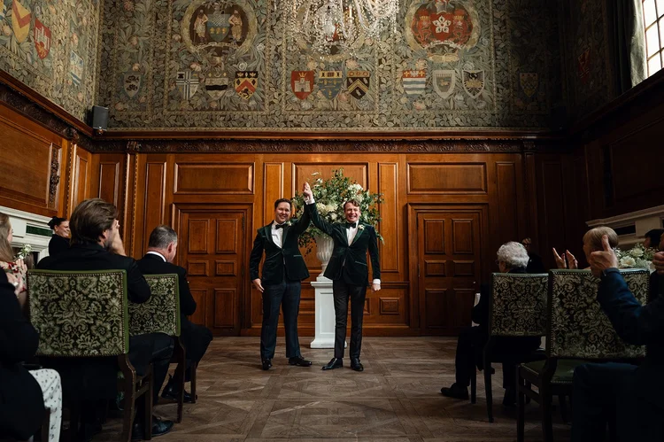 Grooms walking back down the aisle in the Tapestry Room at The Ned Hotel, London
