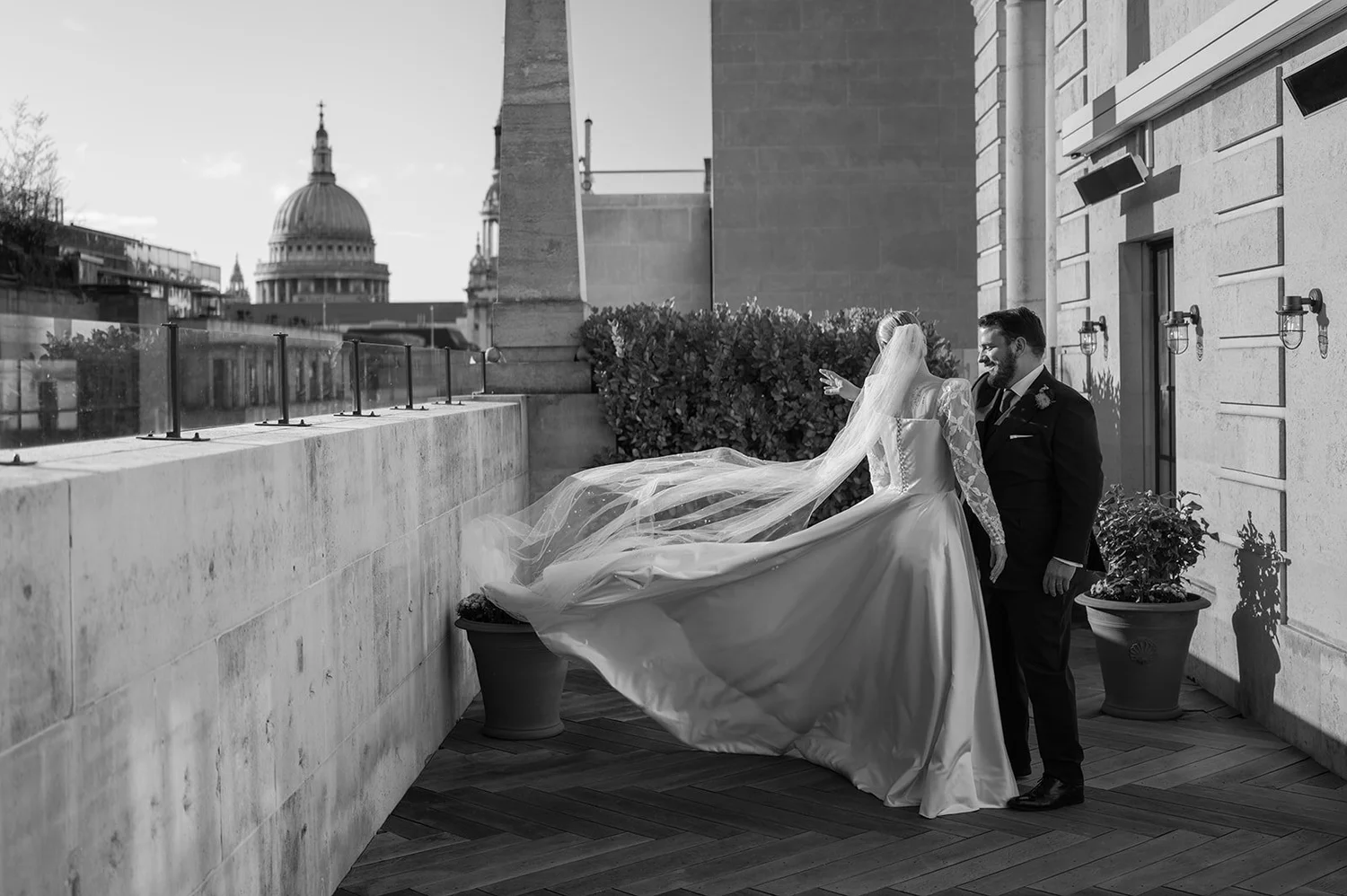 Bride&rsquo;s train catching the wind on the terrace at The Ned, St Paul&rsquo;s Cathedral behind