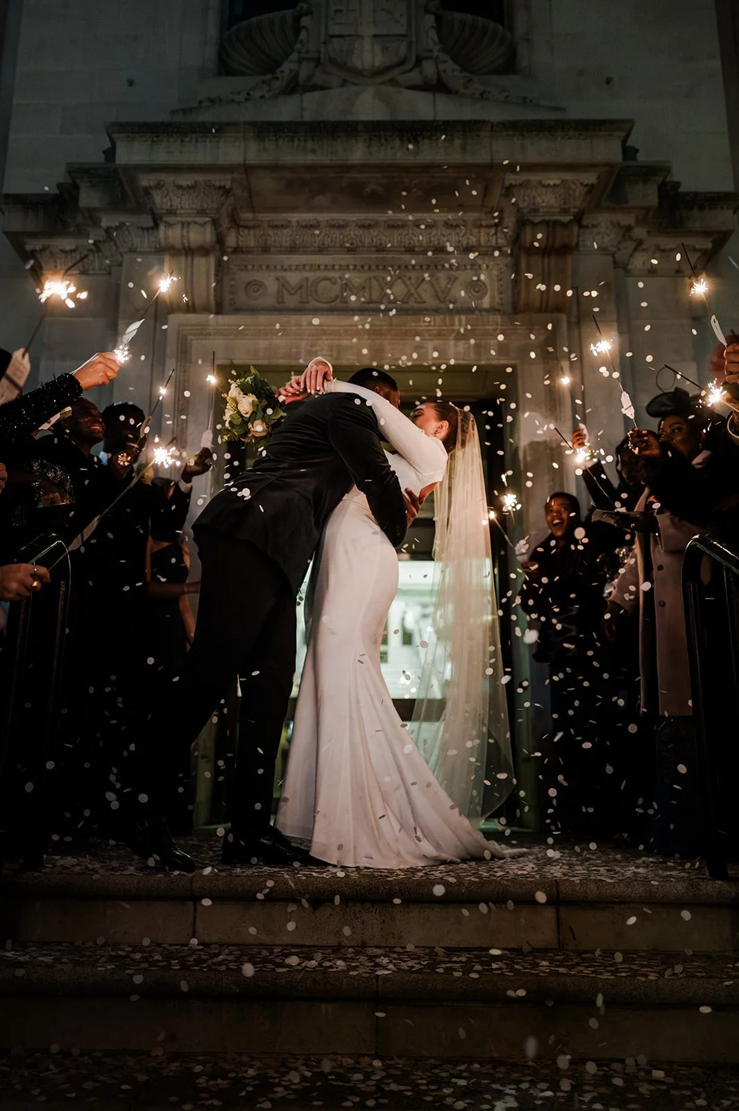 Sophie and Dan kissing under the lights outside Islington Town Hall in December