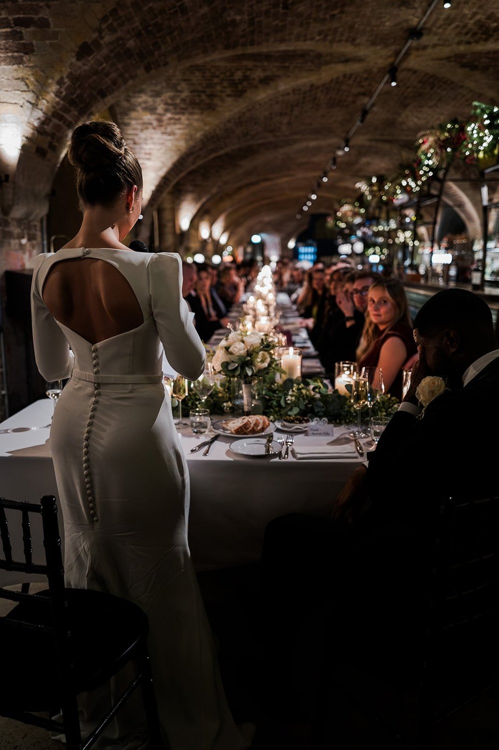 A guest walking past the candlelit tables at the reception