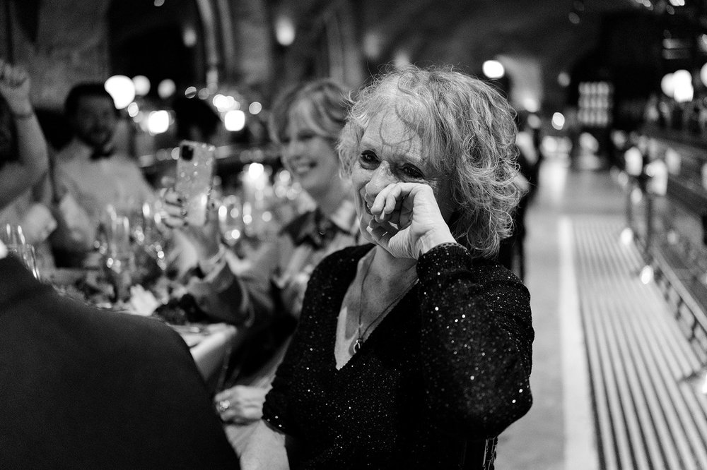 Black and white photograph of guests listening at the wedding breakfast