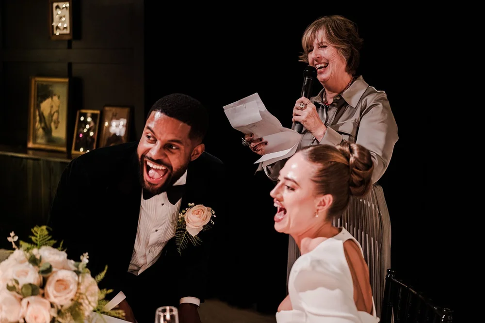 Sophie and Dan laughing during the wedding speeches