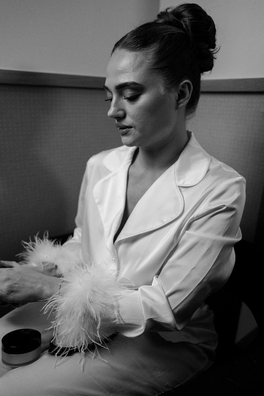 Sophie in a feather-trimmed jacket getting ready on the morning of her Islington Town Hall wedding
