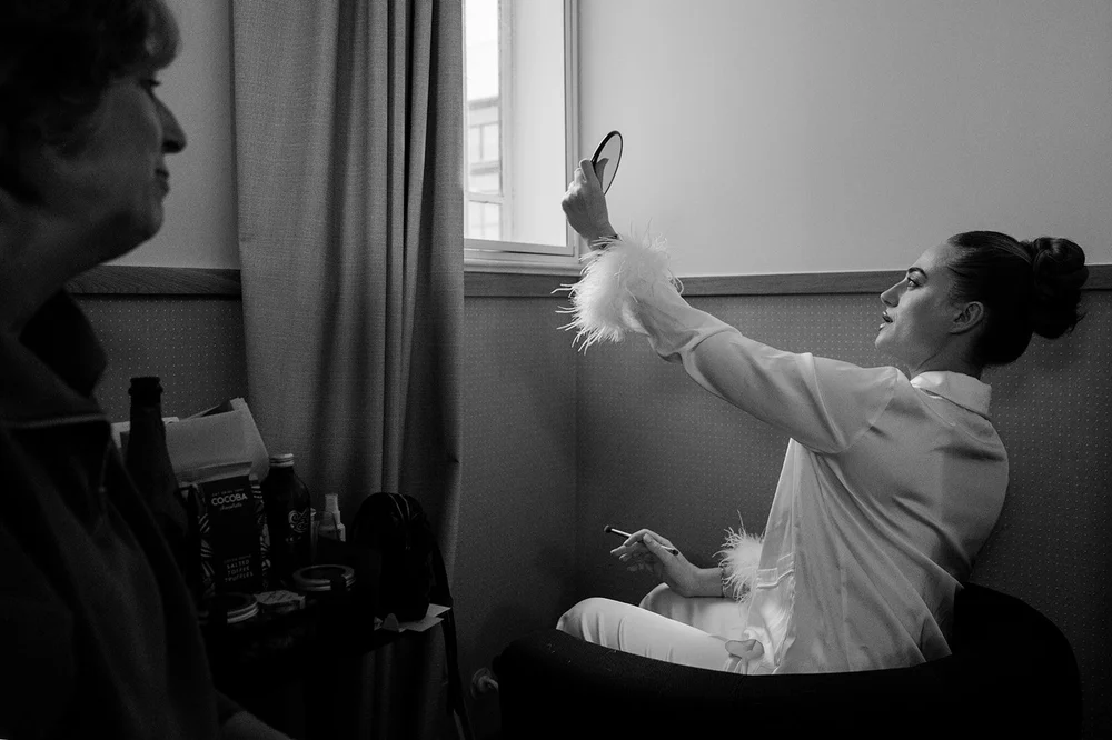 Black and white photograph of Sophie laughing during her wedding morning preparations in London