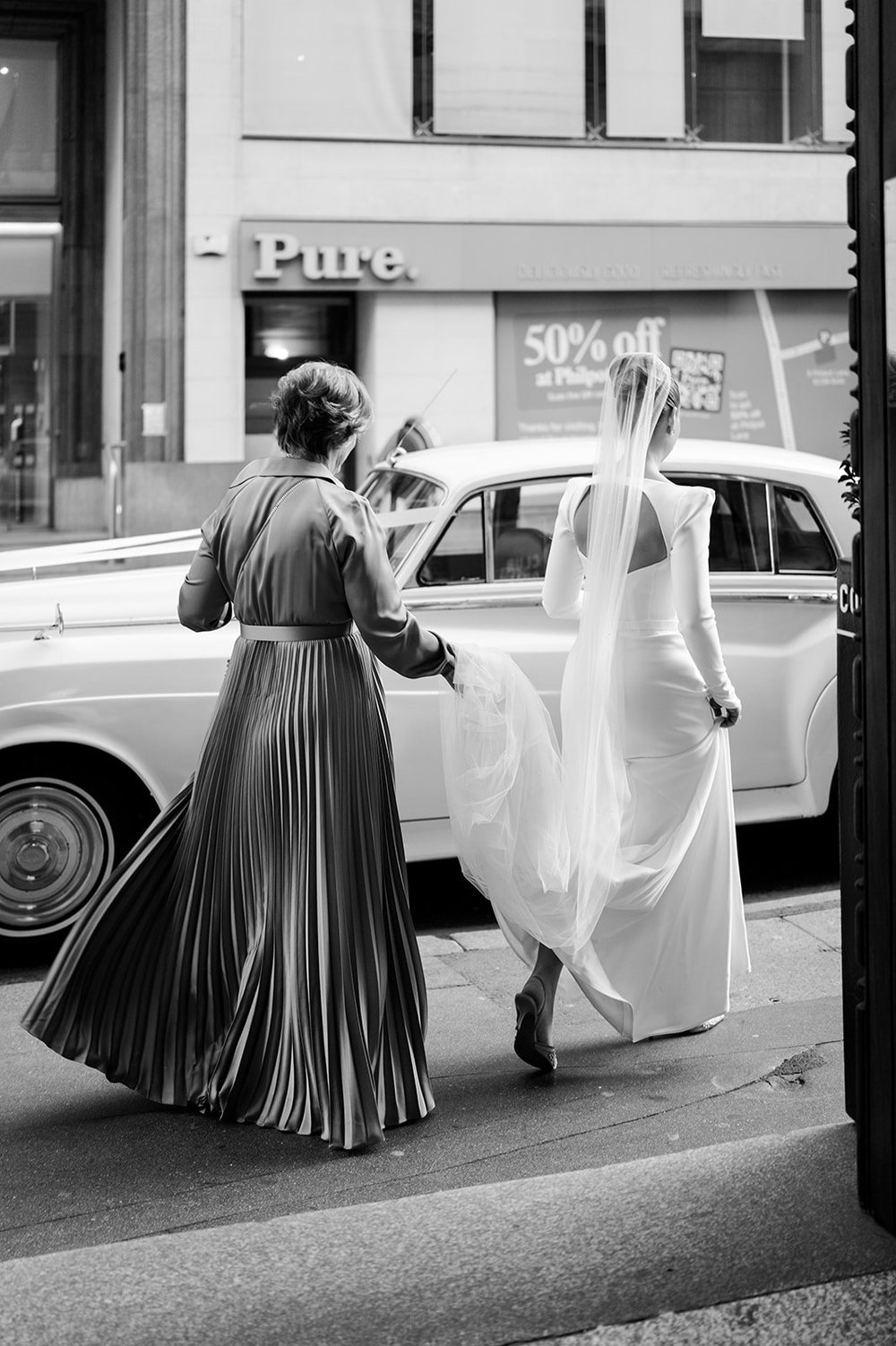 Sophie arriving at Islington Town Hall with her dress carried behind her
