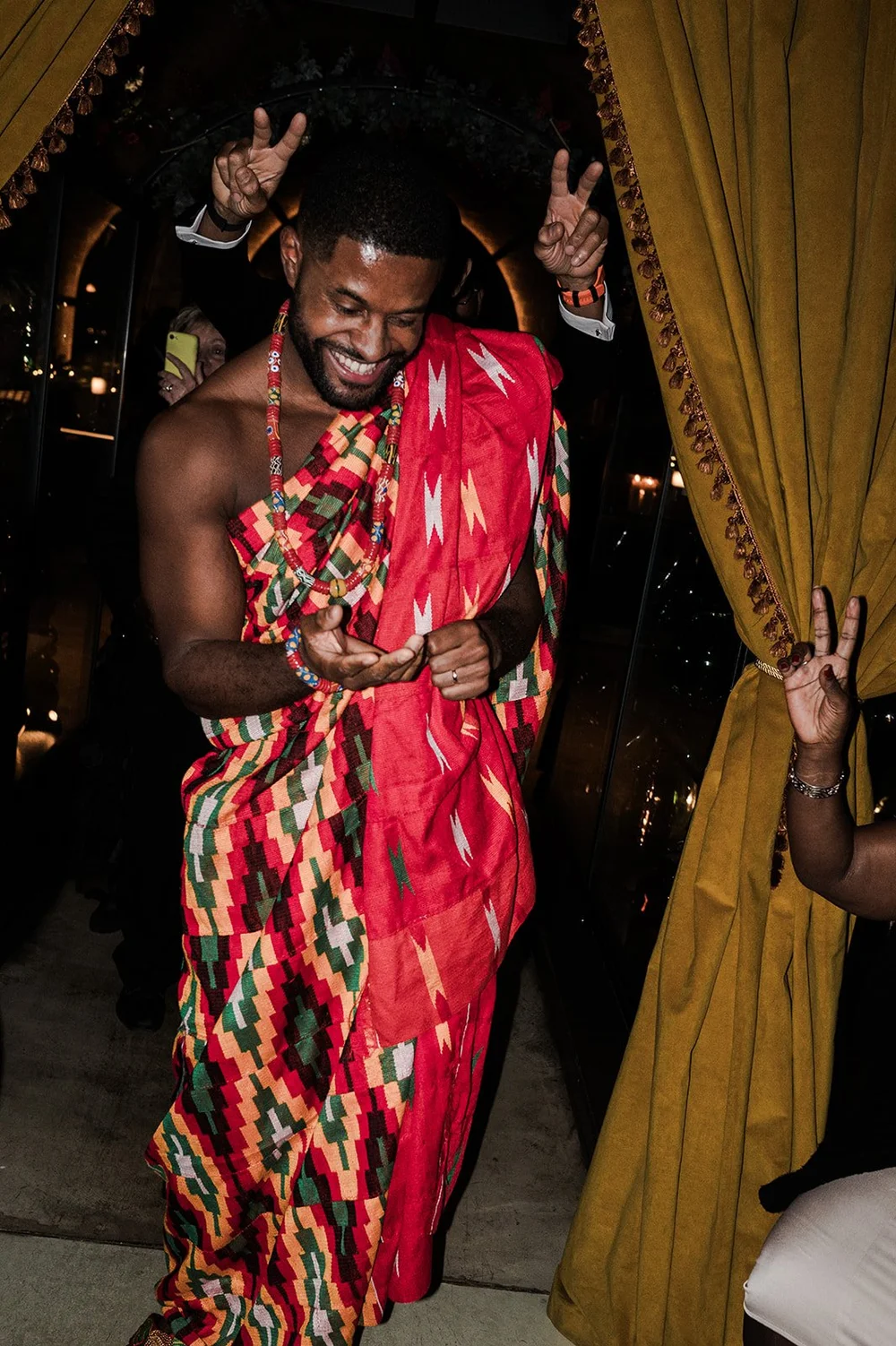 Dan wearing kente cloth draped over one shoulder for the second half of the party