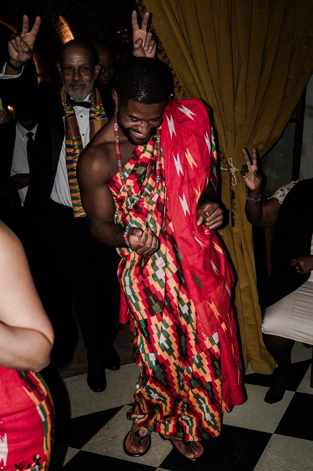 Dan dancing in traditional Ghanaian kente cloth at his wedding reception