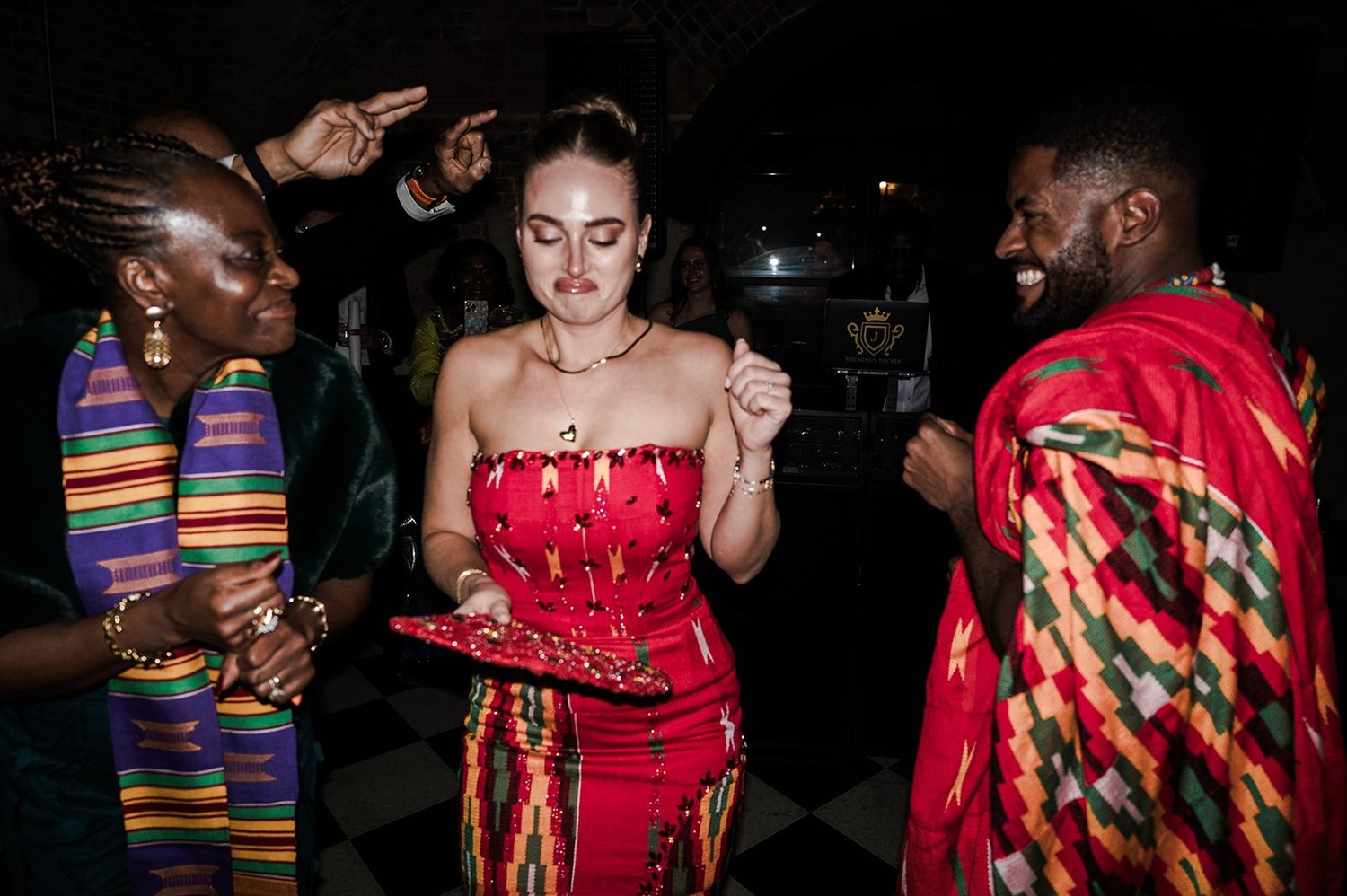 Sophie and Dan dancing in traditional Ghanaian dress surrounded by their guests