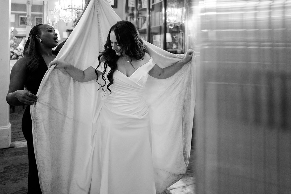 Black and white photograph of Chloe&rsquo;s dress being carried through Brunswick House