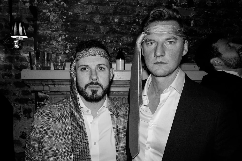 Black and white photograph of two guests at the end of the night