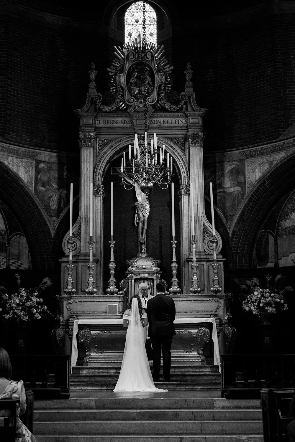 Black and white photograph of Chloe and Jon at the altar at St Mary&rsquo;s Bourne Street