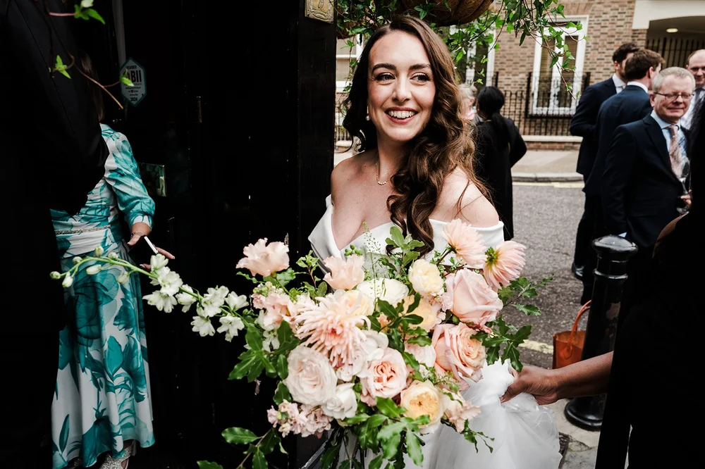 Chloe holding her bouquet at the drinks reception outside the pub