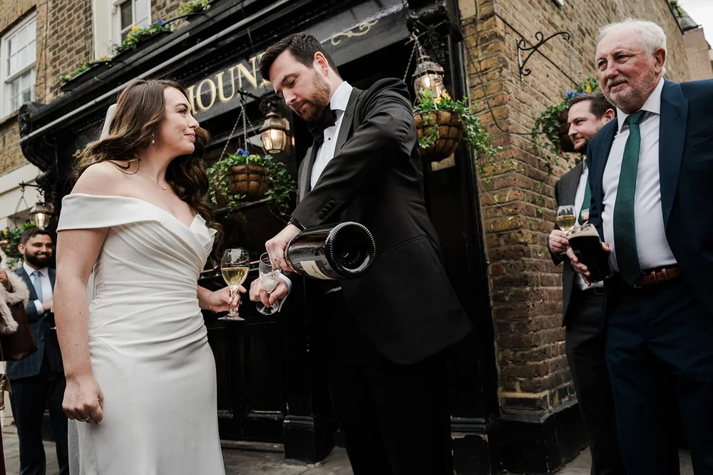 Champagne being poured outside the Fox and Hounds pub