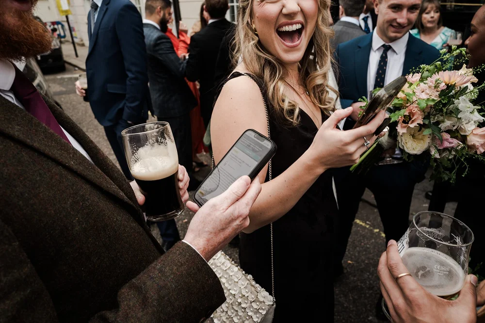 Guests laughing with pints at the Fox and Hounds drinks reception