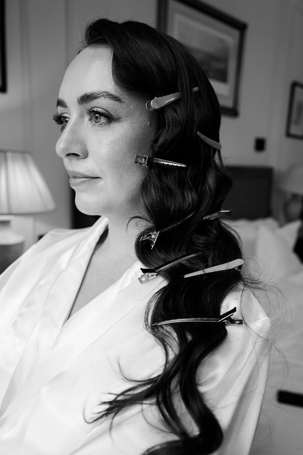 Black and white portrait of Chloe having her hair done before the ceremony