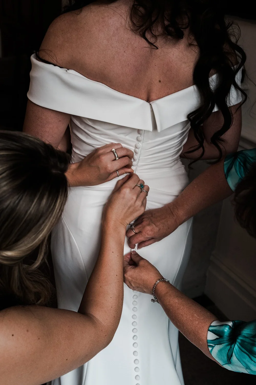 Chloe&rsquo;s dress being buttoned before the wedding ceremony