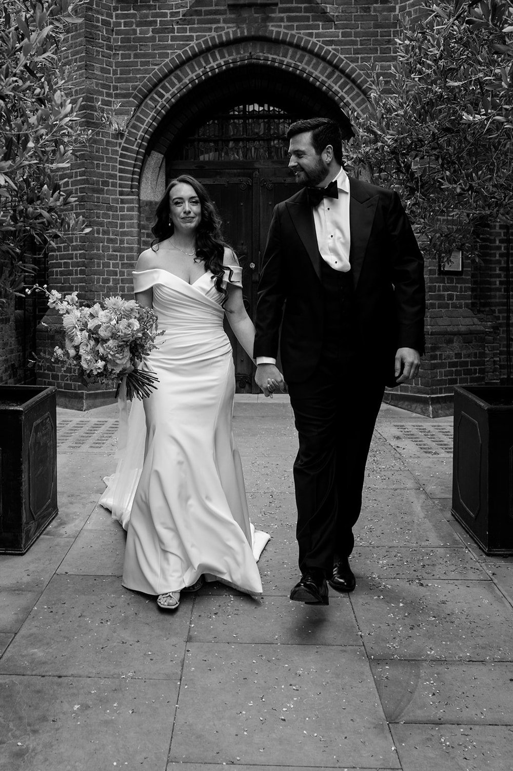Black and white photograph of Chloe and Jon on Bourne Street after the ceremony