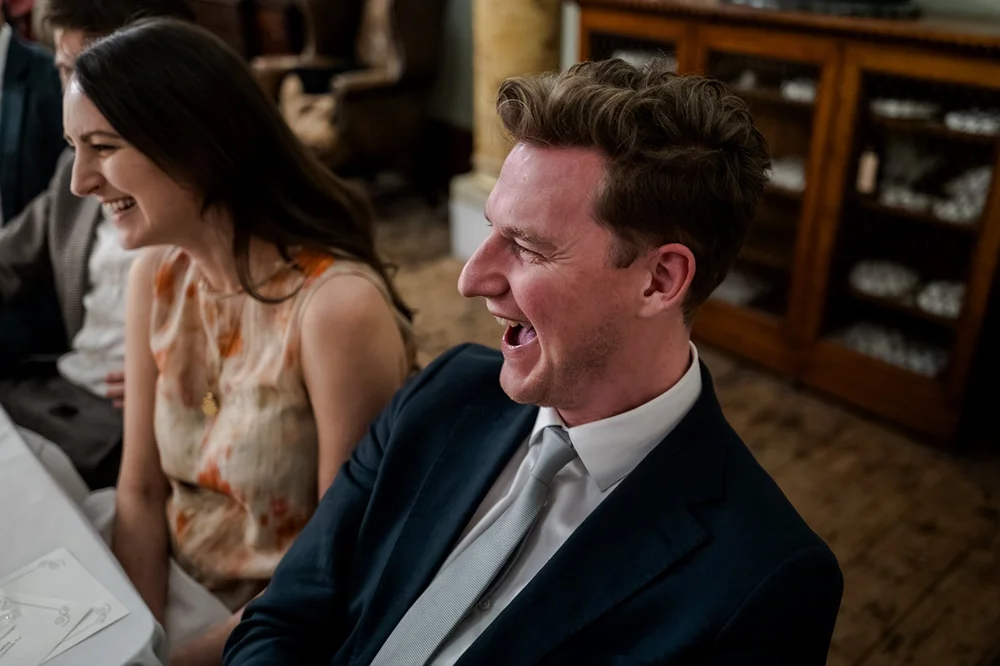 Guests laughing during the speeches at the wedding breakfast