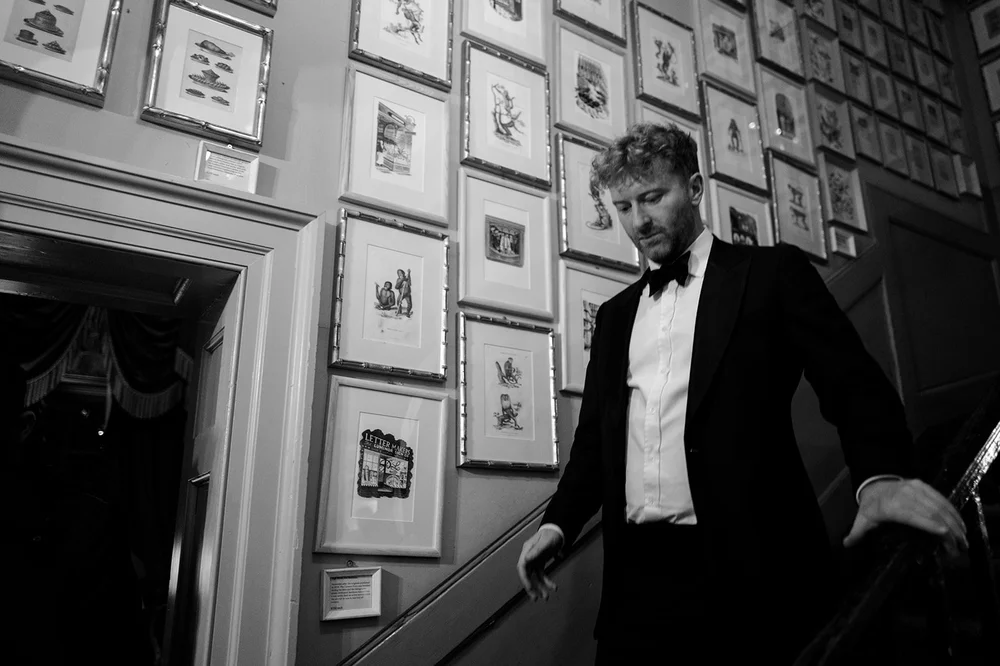 Black and white photograph of a guest coming down the stairs at Brunswick House