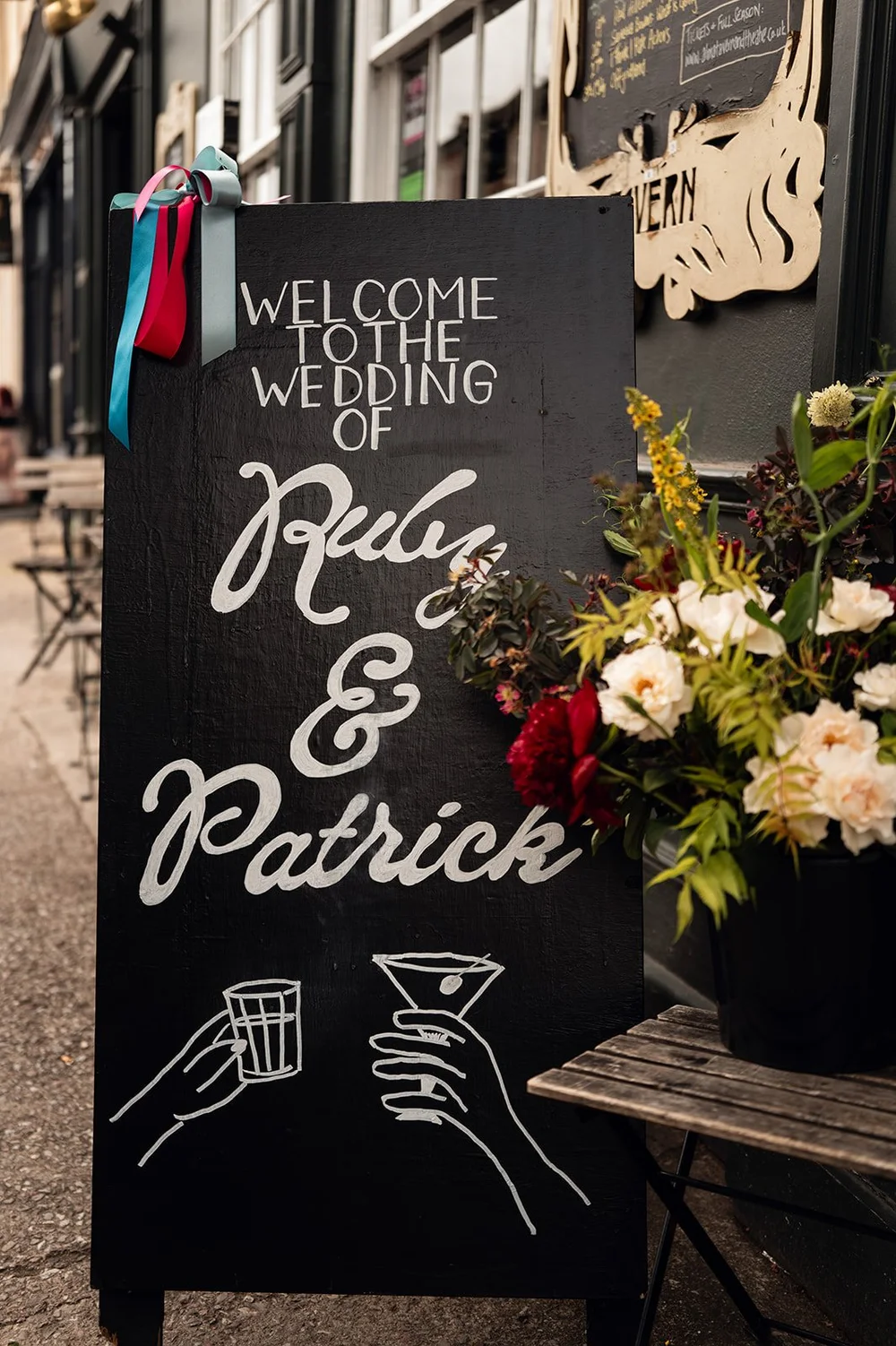 A chalkboard reading Welcome to the wedding of Ruby and Patrick at The Alma Tavern