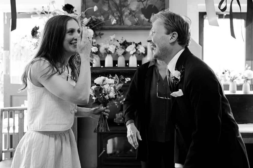 Black and white photograph of Ruby laughing with her father before the ceremony