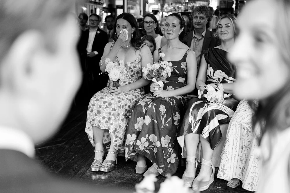 Black and white photograph of guests laughing during the ceremony
