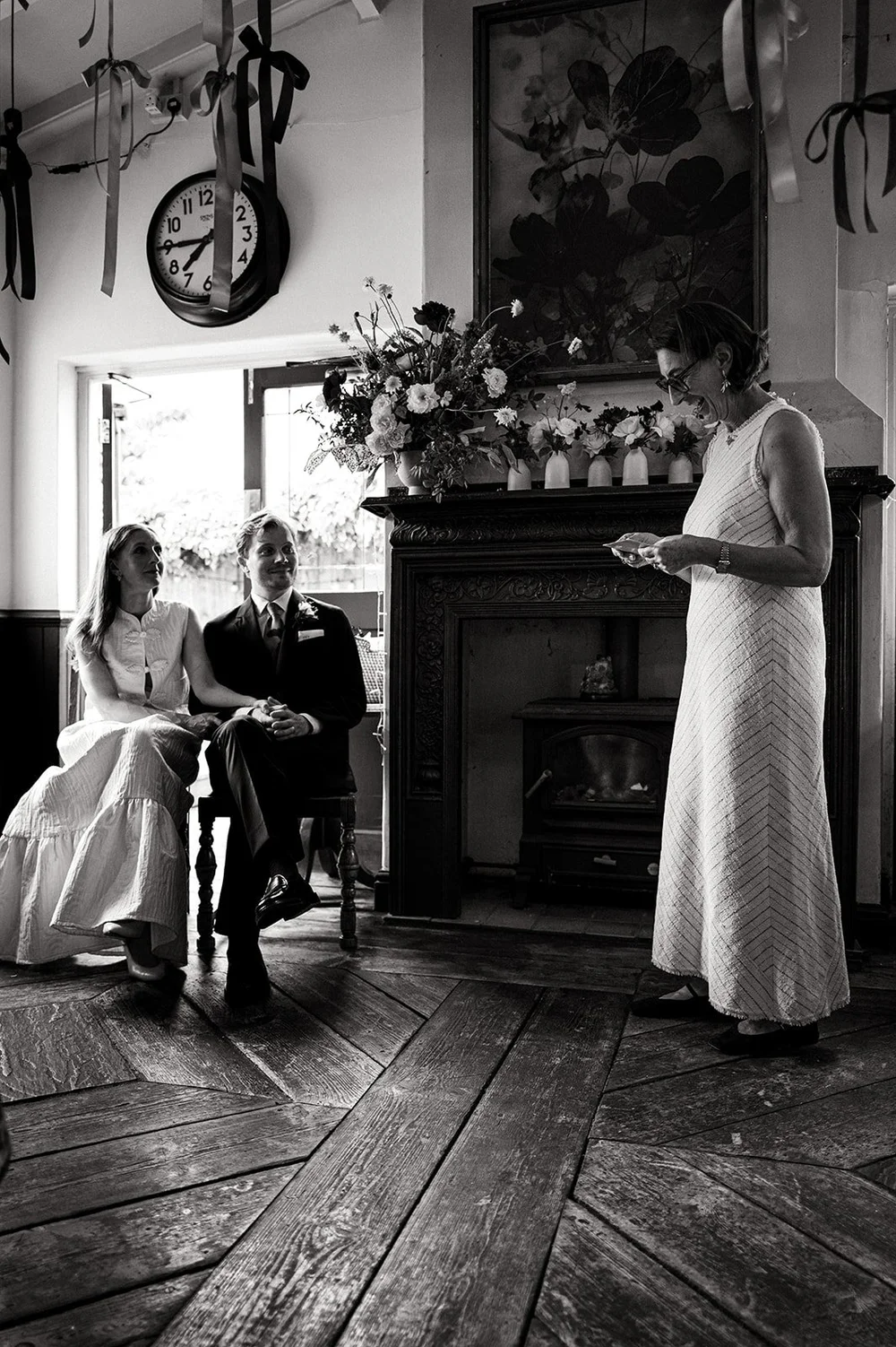 Ruby standing by the fireplace during the ceremony at The Alma Tavern