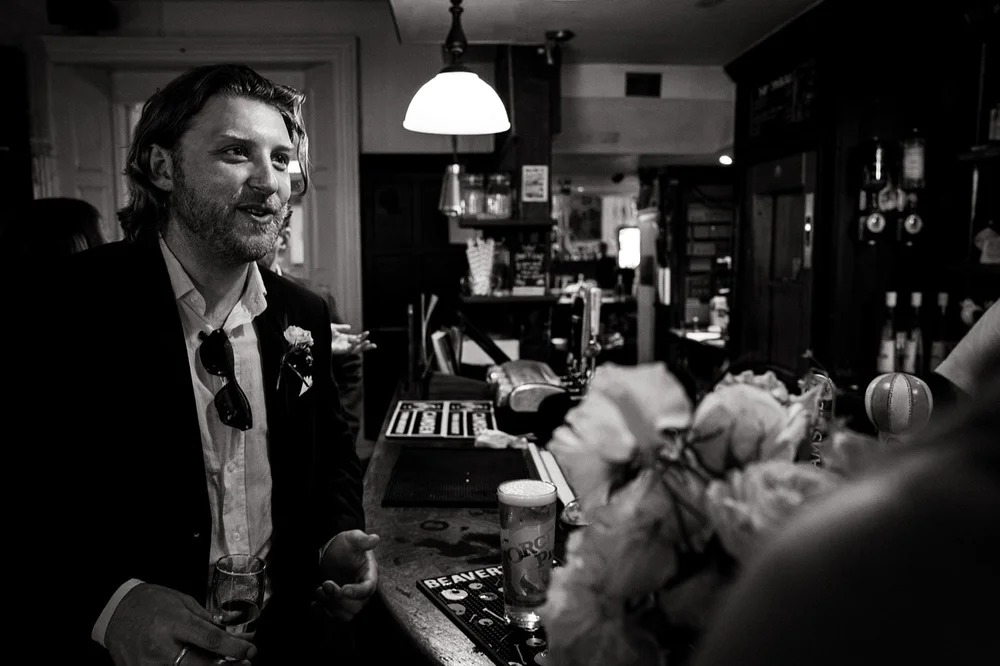 Black and white photograph of guests in the pub after the ceremony