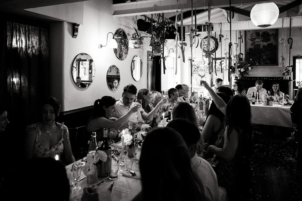 Black and white photograph of guests in the pub during the celebration
