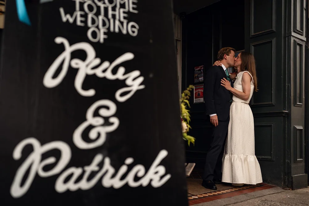 Ruby beside the chalkboard sign for her wedding at The Alma Tavern