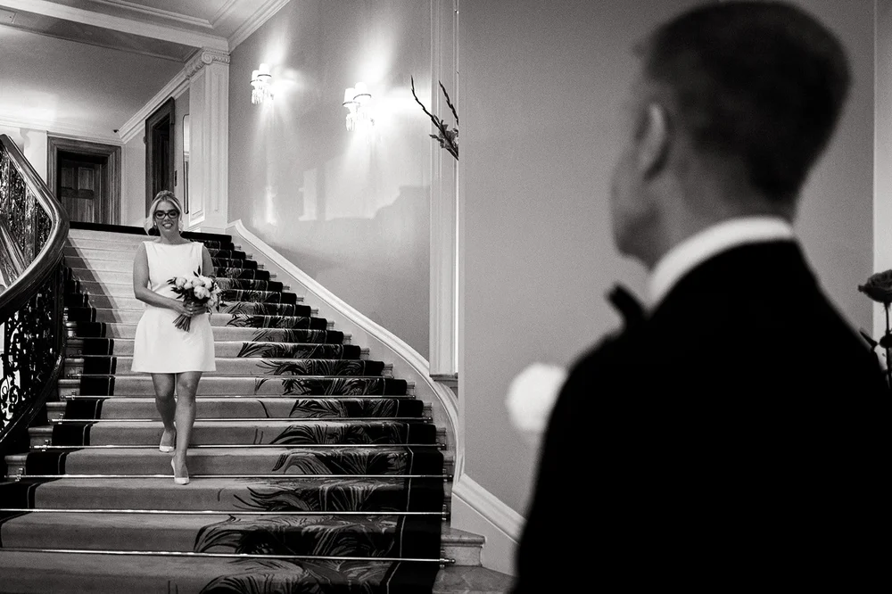 Black and white photograph of Joe on the staircase at Claridge&rsquo;s
