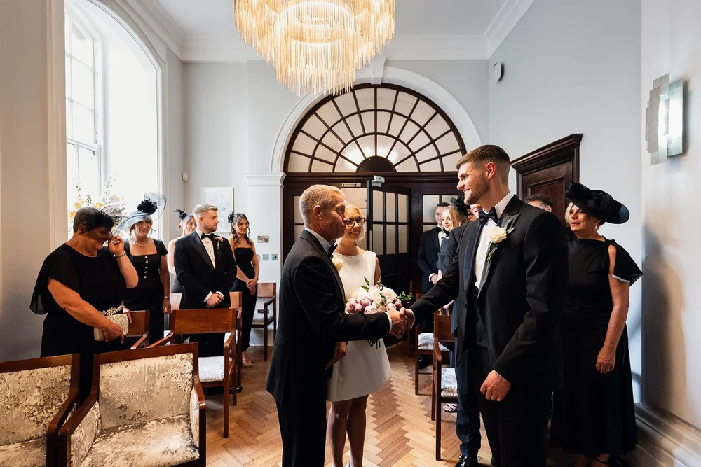 Guests standing for the ceremony in the Rossetti Room at Chelsea Old Town Hall