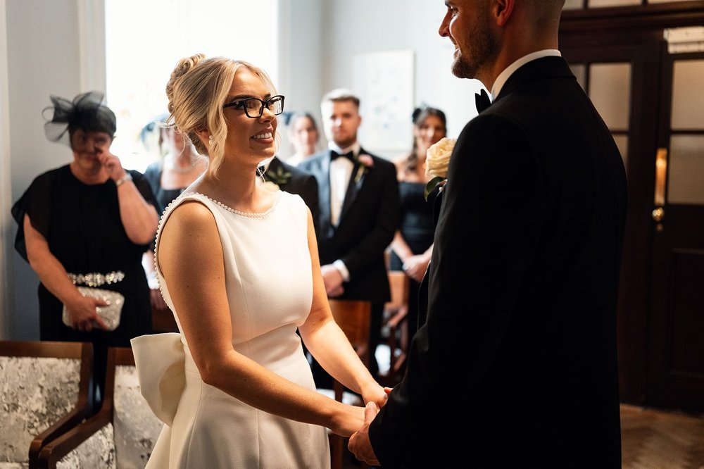 Charley and Joe holding hands during the ceremony in the Rossetti Room
