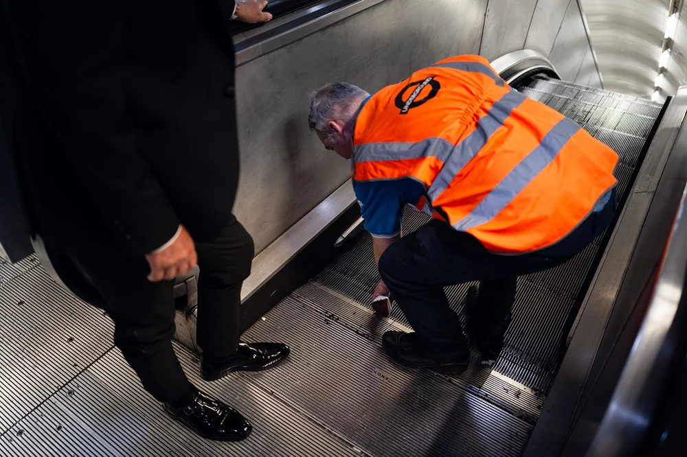 A Transport for London engineer retrieving the shoe from the escalator at Bond Street
