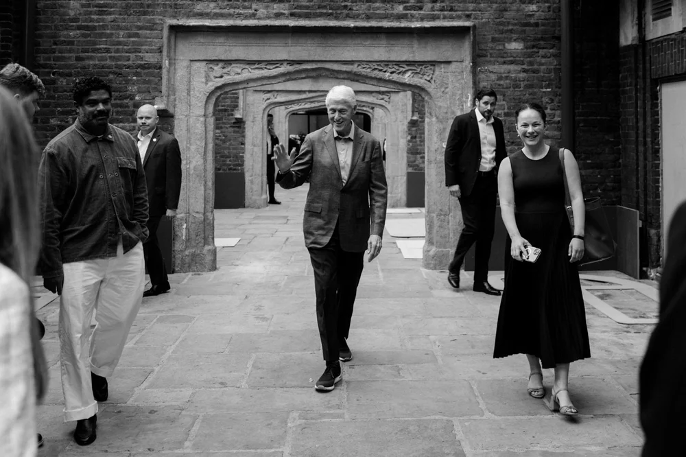 Bill Clinton waving as he arrives through the arcade at Kensington Roof Gardens, London