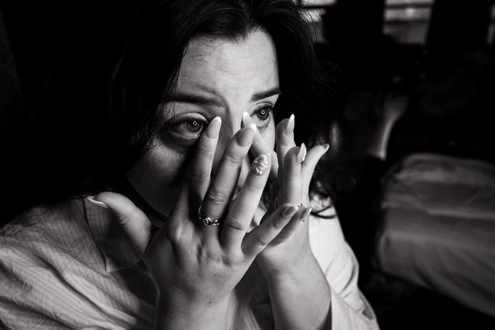 A guest overcome with emotion, hands to her face, during the ceremony
