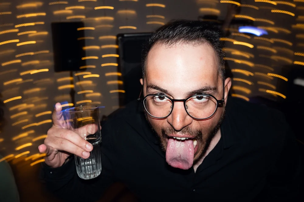 A guest pulling a face at the camera with a drink in his hand