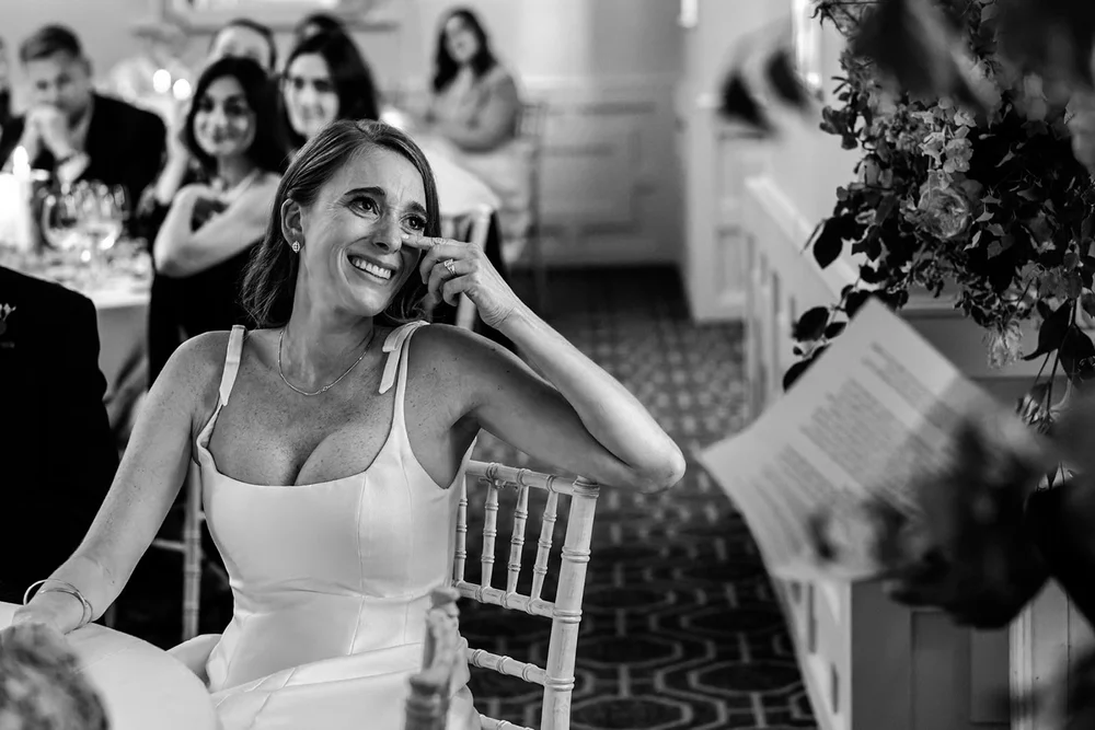 Bride laughing during a speech at the wedding breakfast