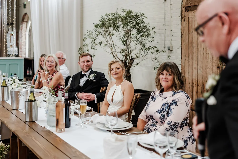 Guests seated along a long table at the wedding breakfast