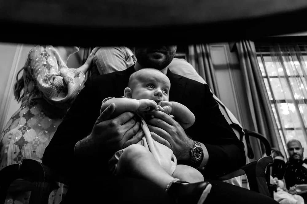 A baby guest held on a lap during the wedding morning