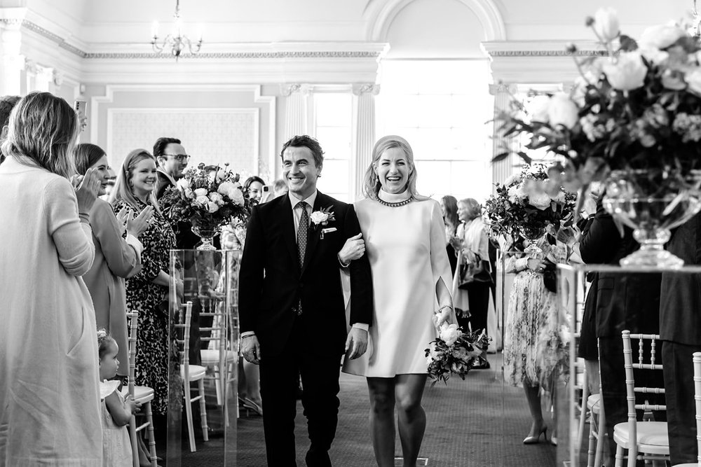 Groom walking down the aisle with his mother