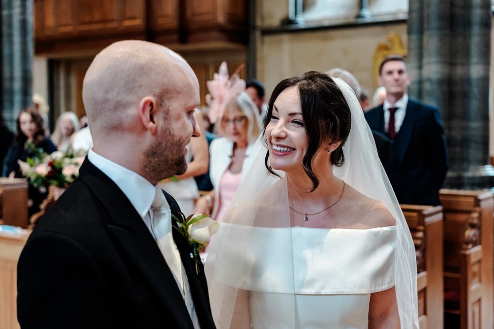 Bride and groom smiling as they walk back up the aisle