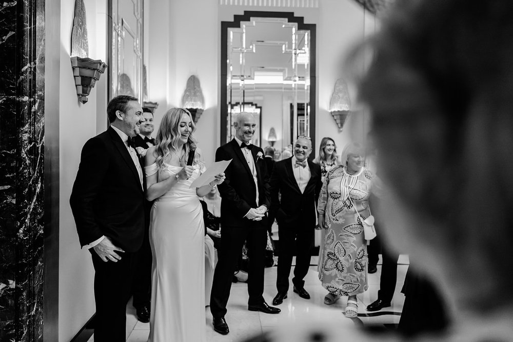 Bride and groom greeting their guests in a mirrored hallway