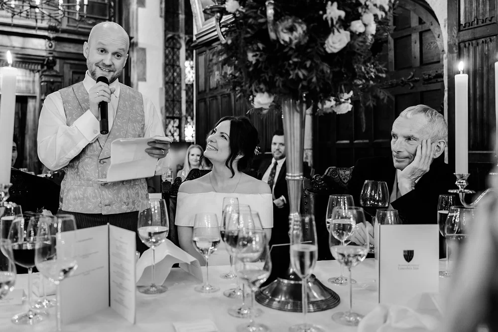 A guest delivering a speech at a candlelit wedding breakfast