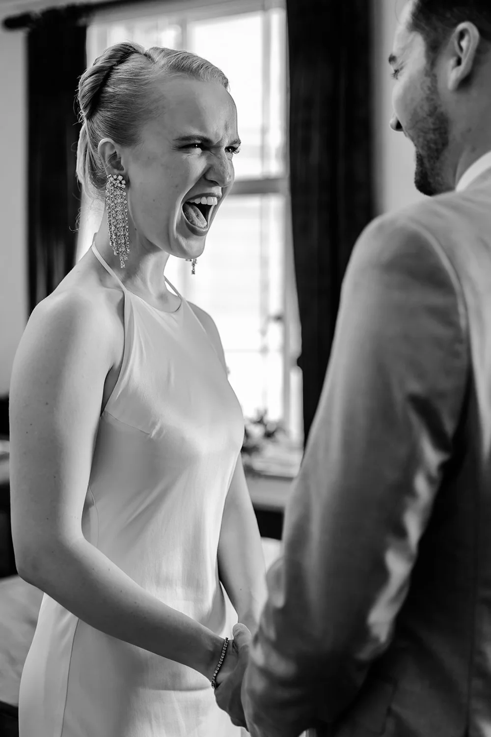 Bride laughing with delight as she faces her groom