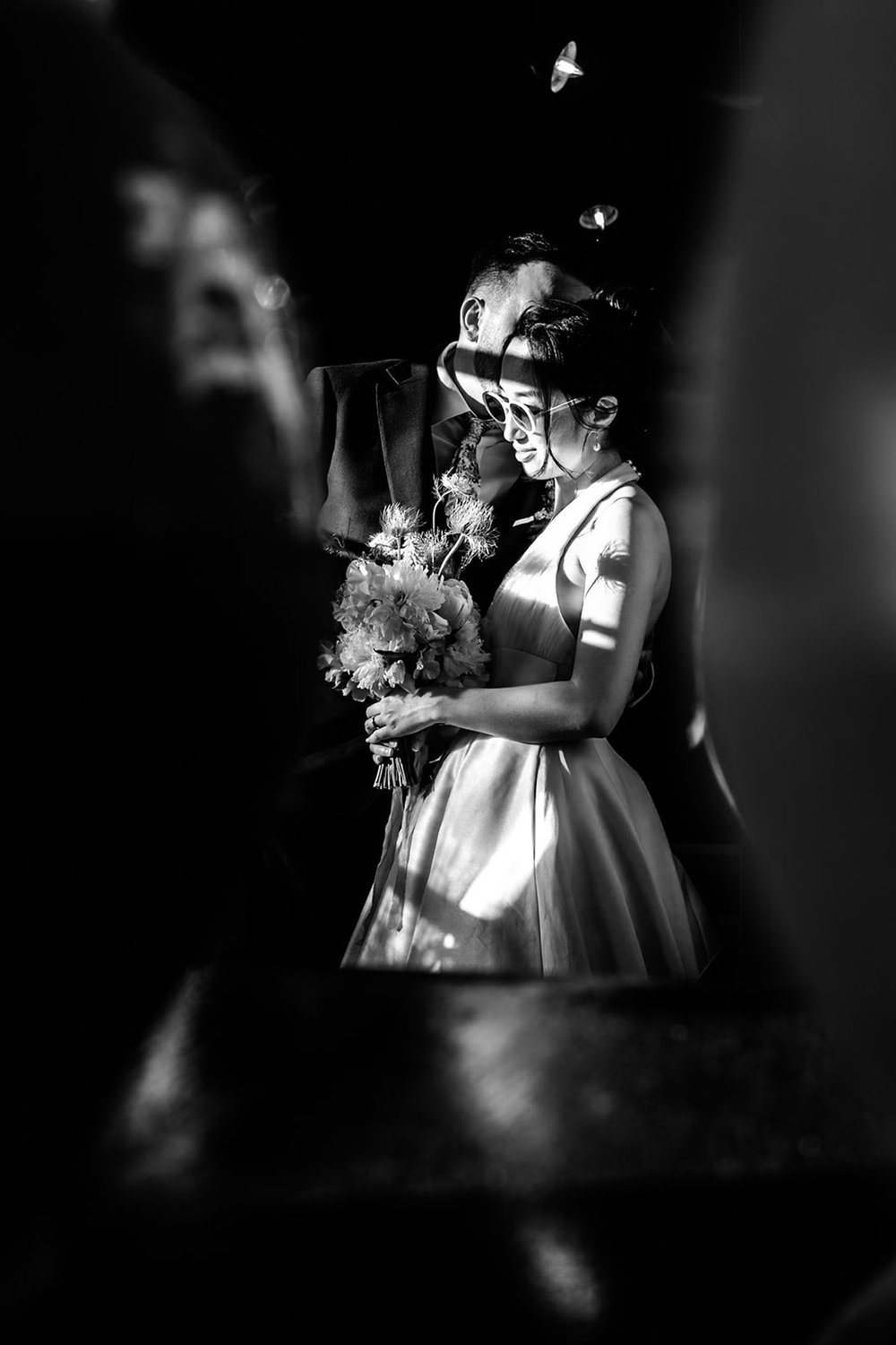 A flower girl caught in a shaft of light holding her bouquet