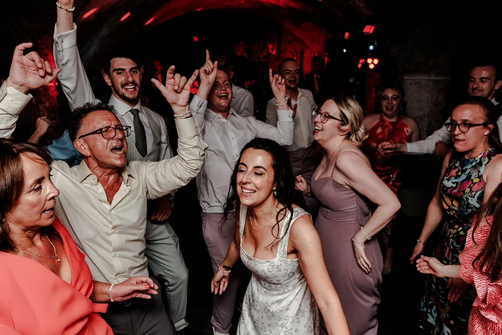 Guests with their arms in the air on a packed dance floor