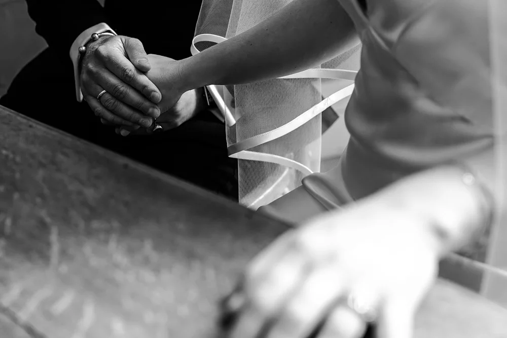 Close up of the couple&rsquo;s hands together as they cut the cake